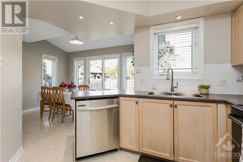 The kitchen overlooks a large, fenced backyard complete with a new cedar deck. - 48 Eagleview Street, Ottawa, ON - Indoor Photo Showing Kitchen With Double Sink