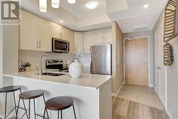 Kitchen featuring a kitchen breakfast bar, decorative backsplash, sink, and appliances with stainless steel finishes - 