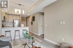 Kitchen featuring kitchen peninsula, appliances with stainless steel finishes, a kitchen breakfast bar, tasteful backsplash, and light hardwood / wood-style floors - 