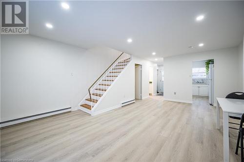 Unfurnished living room featuring baseboard heating and light hardwood / wood-style flooring - 212 Westcourt Place, Waterloo, ON - Indoor Photo Showing Other Room