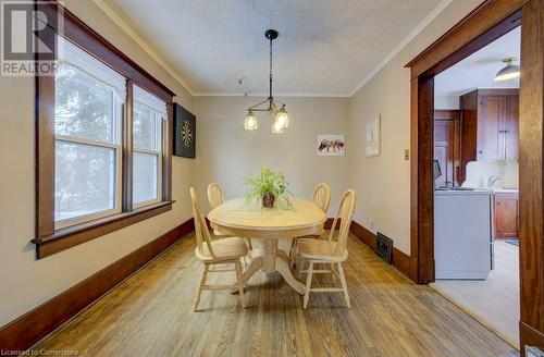 Dining area featuring sink, light wood-type flooring, ornamental molding, and an inviting chandelier - 97 Peppler Street, Waterloo, ON - Indoor Photo Showing Dining Room