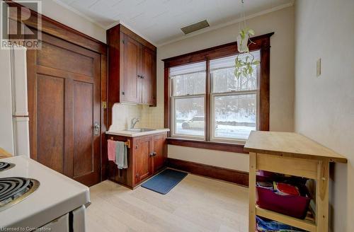 Kitchen featuring white fridge, ornamental molding, sink, light hardwood / wood-style flooring, and tasteful backsplash - 97 Peppler Street, Waterloo, ON - Indoor Photo Showing Other Room