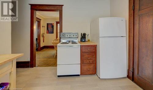 Kitchen with white appliances, light wood-type flooring, and ornamental molding - 97 Peppler Street, Waterloo, ON - Indoor