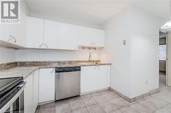 Kitchen featuring stainless steel appliances, white cabinets, decorative light fixtures, and sink - 