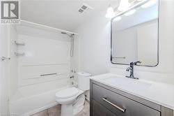 Full bathroom with shower / bath combination, toilet, vanity, and tile patterned flooring - 