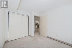 Unfurnished bedroom featuring light colored carpet and a closet - 