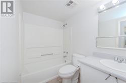 Full bathroom featuring toilet, tile patterned flooring, shower / bathing tub combination, and sink - 