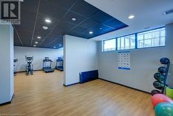 Workout area with hardwood / wood-style floors and a drop ceiling - 