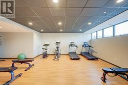 Workout room featuring a drop ceiling and wood-type flooring - 