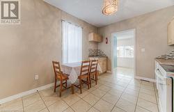 Dining area featuring sink, light tile patterned floors, and a chandelier - 