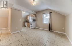 Kitchen with light tile patterned floors, tasteful backsplash, white appliances, vaulted ceiling, and sink - 