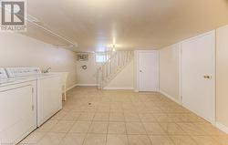 Washroom featuring light tile patterned floors and washer and clothes dryer - 