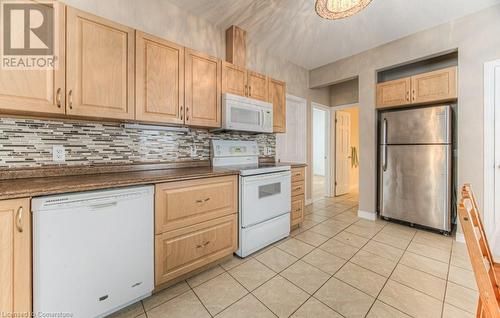 Kitchen featuring light brown cabinets, decorative backsplash, and white appliances - 67 Wellington Street N, Kitchener, ON - Indoor Photo Showing Kitchen