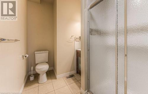 Bathroom featuring toilet, tile patterned flooring, an enclosed shower, and vanity - 67 Wellington Street N, Kitchener, ON - Indoor Photo Showing Bathroom