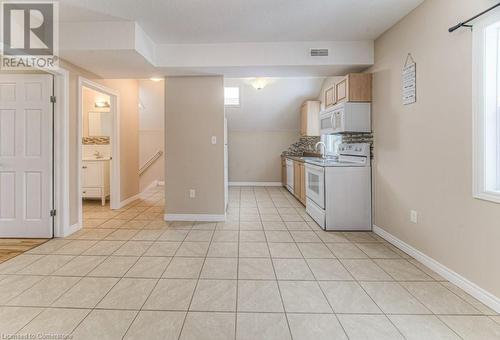 Kitchen featuring tasteful backsplash, sink, white appliances, light tile patterned floors, and light brown cabinetry - 67 Wellington Street N, Kitchener, ON - Indoor Photo Showing Kitchen