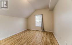 Bonus room with lofted ceiling and light hardwood / wood-style floors - 