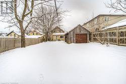 Snowy yard featuring an outbuilding and a garage - 