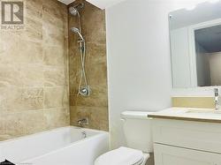 Full bathroom with tiled shower / bath, vanity, and toilet - 