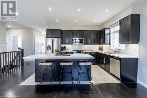 Kitchen with a breakfast bar, stainless steel appliances, a center island, and sink - 219 Falconridge Drive, Kitchener, ON - Indoor Photo Showing Kitchen With Stainless Steel Kitchen With Upgraded Kitchen