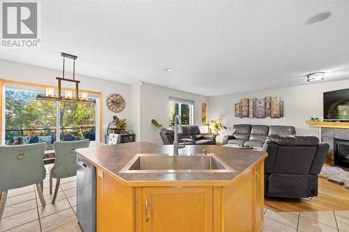 209 Tuscany Ravine Road Nw, Calgary, AB - Indoor Photo Showing Kitchen With Fireplace With Double Sink