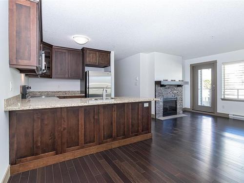 202-257 Moilliet St South, Parksville, BC - Indoor Photo Showing Kitchen With Fireplace