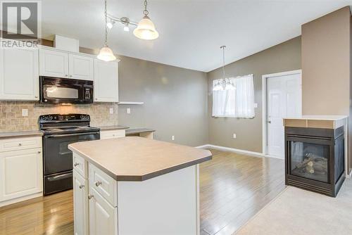 572 Sunridge Crescent W, Lethbridge, AB - Indoor Photo Showing Kitchen With Fireplace