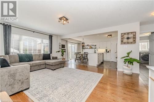 Living room with washer / clothes dryer, light hardwood / wood-style flooring, and sink - 12 Hardcastle Place, Cambridge, ON - Indoor Photo Showing Living Room