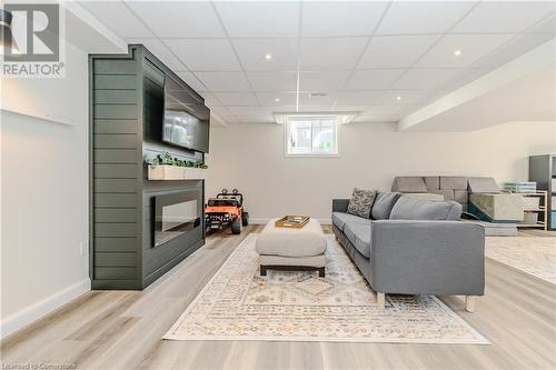 Living room with a paneled ceiling and light hardwood / wood-style floors - 12 Hardcastle Place, Cambridge, ON - Indoor With Fireplace