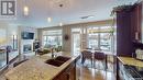 4421 Sandpiper Crescent E, Regina, SK  - Indoor Photo Showing Kitchen With Fireplace With Double Sink 