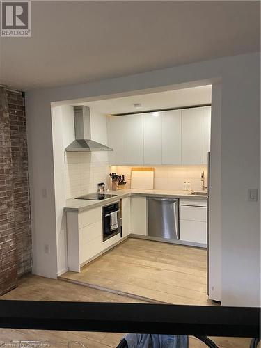 Kitchen with range hood, dishwasher, stovetop, white cabinets, and oven - 67 Louisa Street, Kitchener, ON - Indoor Photo Showing Kitchen