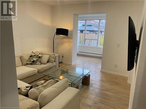 Living room with a baseboard radiator and light hardwood / wood-style floors - 67 Louisa Street, Kitchener, ON - Indoor