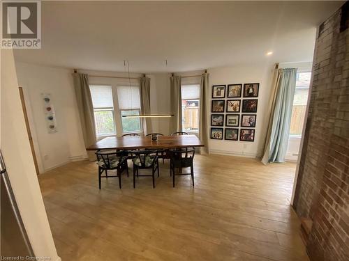 Dining area with light hardwood / wood-style flooring and brick wall - 67 Louisa Street, Kitchener, ON - Indoor Photo Showing Dining Room