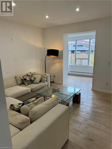 Living room with light wood-type flooring and baseboard heating - 67 Louisa Street, Kitchener, ON - Indoor Photo Showing Living Room