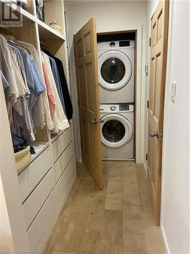 Laundry area featuring stacked washer and clothes dryer and light wood-type flooring - 67 Louisa Street, Kitchener, ON - Indoor Photo Showing Laundry Room