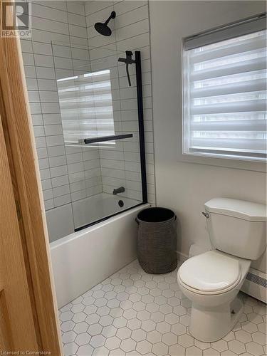 Bathroom with enclosed tub / shower combo, tile patterned floors, and toilet - 67 Louisa Street, Kitchener, ON - Indoor Photo Showing Bathroom