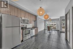 Kitchen with stainless steel appliances, sink, decorative backsplash, and decorative light fixtures - 