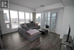 Living room featuring dark hardwood / wood-style flooring and a healthy amount of sunlight - 