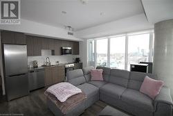 Living room with rail lighting, dark wood-type flooring, and sink - 