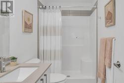 Ensuite with a standing shower and quartz counters. - 