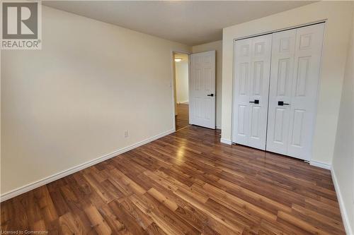 Unfurnished bedroom featuring dark hardwood / wood-style flooring and a closet - 39 Bridlewreath Street, Kitchener, ON - Indoor Photo Showing Other Room