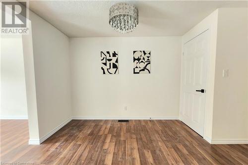 Unfurnished room featuring dark hardwood / wood-style flooring and a textured ceiling - 39 Bridlewreath Street, Kitchener, ON - Indoor Photo Showing Other Room