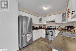 Kitchen featuring white cabinetry, stainless steel appliances, sink, and a textured ceiling - 