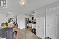 Kitchen featuring white cabinetry and stainless steel refrigerator - 