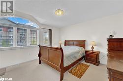 Bedroom with light carpet, lofted ceiling, and a textured ceiling - 