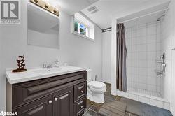 Bathroom with vanity, a shower with curtain, and toilet - 