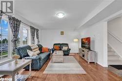 Living room with a textured ceiling and light wood-type flooring - 