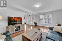 Living room featuring a textured ceiling and light hardwood / wood-style flooring - 