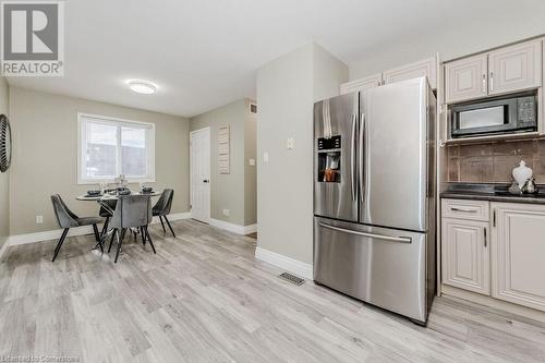 Kitchen featuring stainless steel fridge with ice dispenser, black microwave, and white cabinets - 66 Karen Walk, Waterloo, ON - Indoor