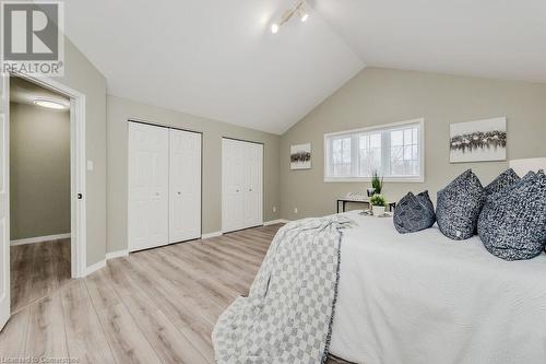 Bedroom featuring lofted ceiling, light hardwood / wood-style flooring, multiple closets, and track lighting - 66 Karen Walk, Waterloo, ON - Indoor Photo Showing Bedroom