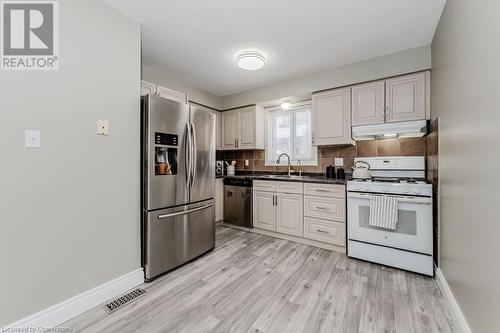 Kitchen with light wood-type flooring, stainless steel appliances, sink, and backsplash - 66 Karen Walk, Waterloo, ON - Indoor Photo Showing Kitchen